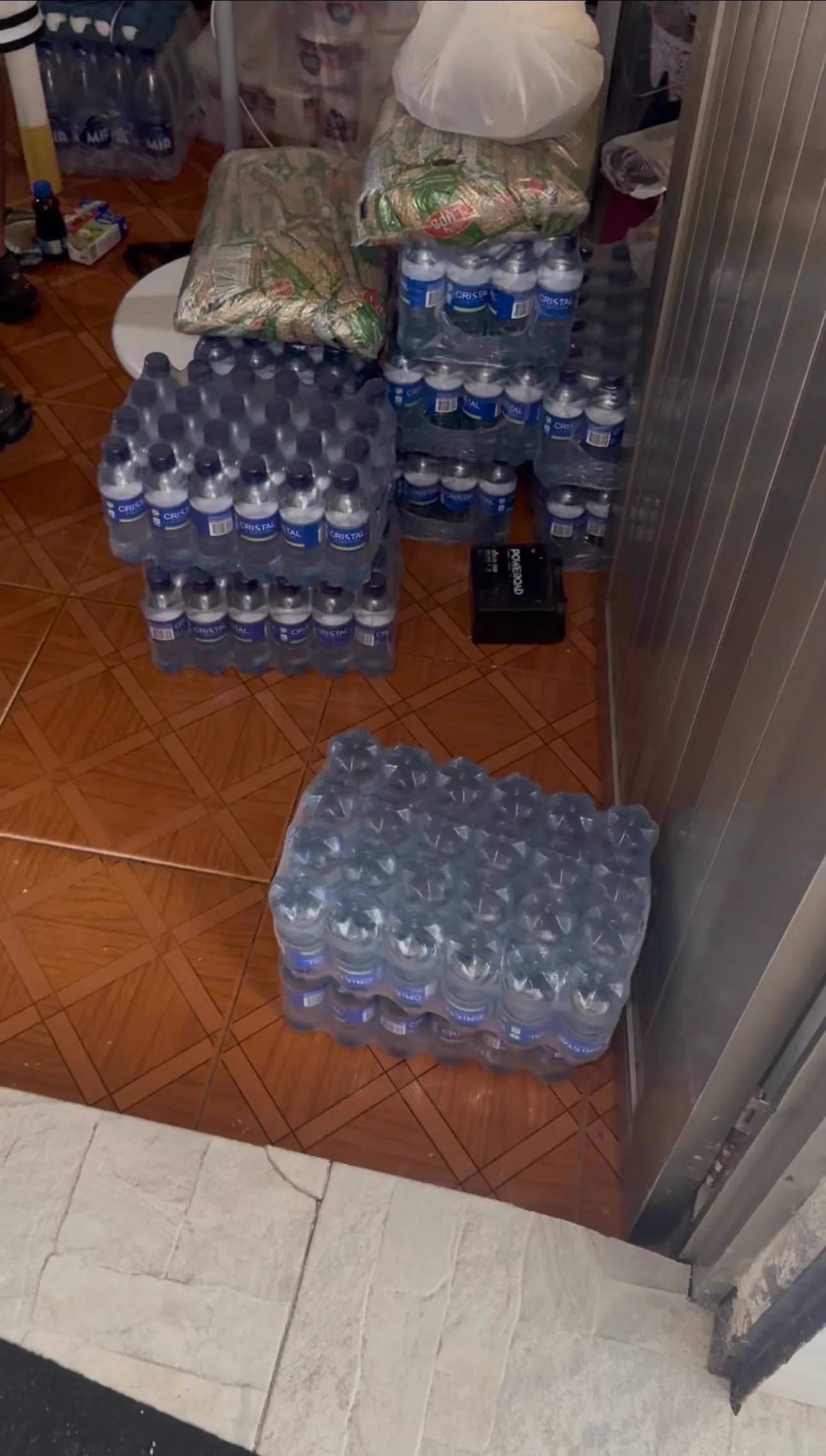 Paquetes de agua potable envasada apilados en el centro de acopio de la corporación en el barrio Cascajal
