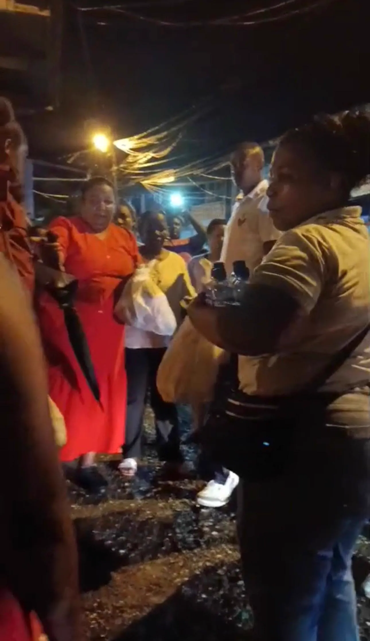 Un grupo de mujeres del barrio recibe las remesas durante la jornada humanitaria nocturna