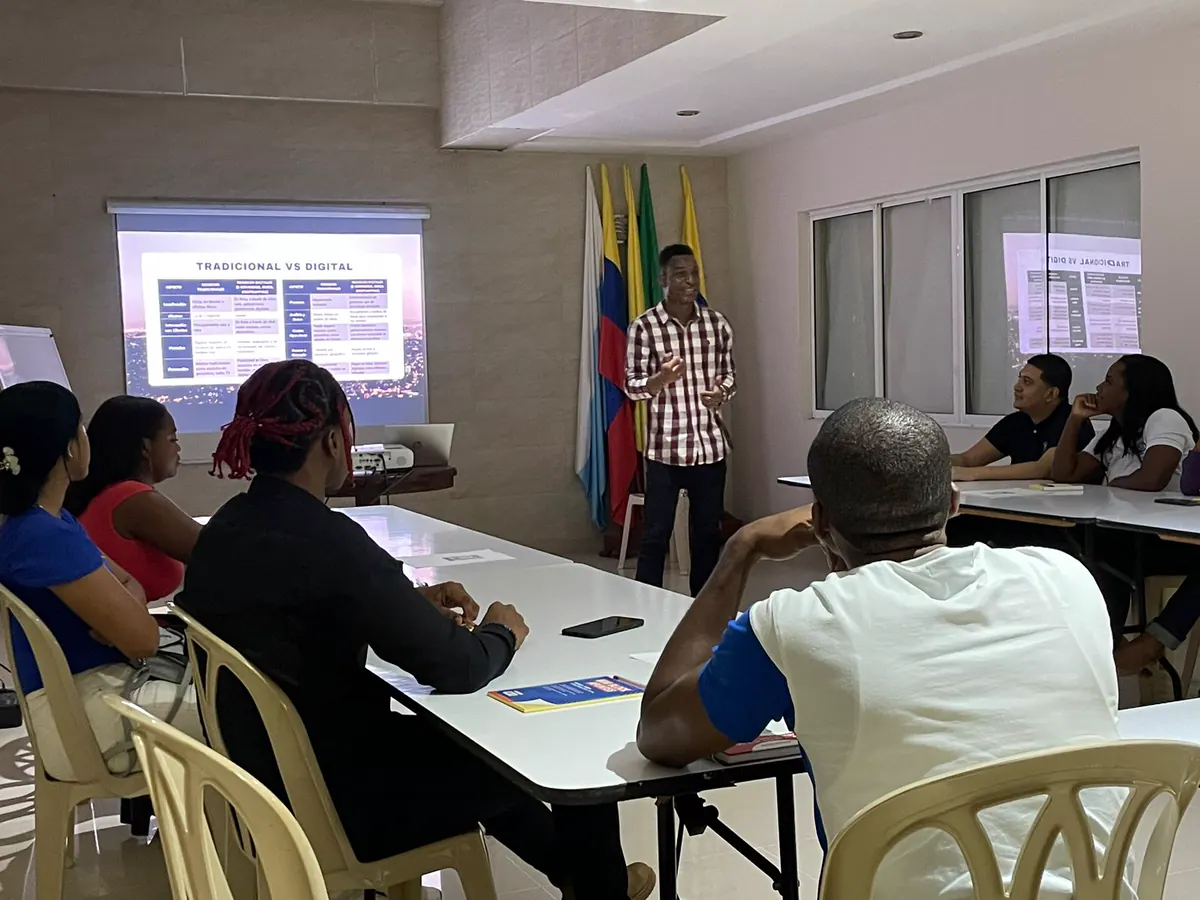 Grupo de líderes comunitarios durante una capacitación de la Corporación Luz de Gracia en un salón con la bandera de Colombia