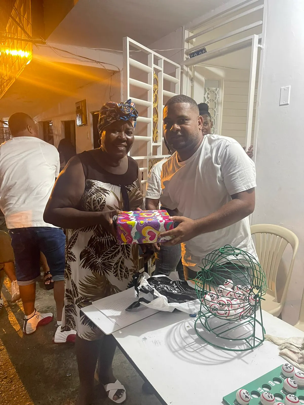 Voluntarios de Luz de Gracia entregan un regalo envuelto a una mujer durante la jornada Navidad con Luz de Gracia