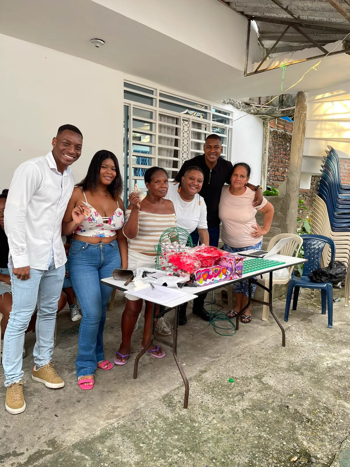 Grupo de voluntarios de Luz de Gracia junto a una mesa con productos en una jornada de emprendimiento barrial